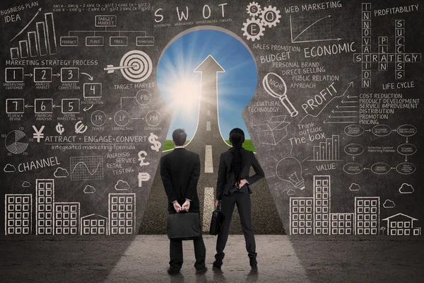 Двое бизнесменов смотрят в брешь в ключах Стоковая Картинка