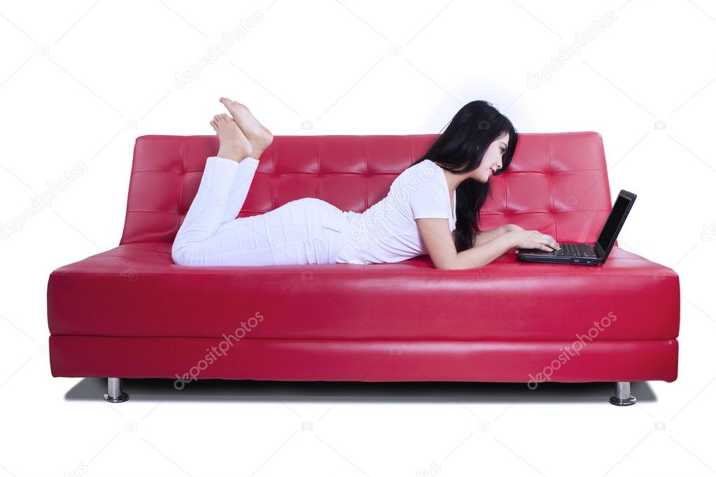 Casual woman on a sofa working with a laptop