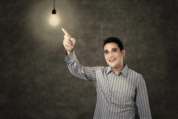 Asiático homem apontando uma lâmpada acesa — Fotografia de Stock