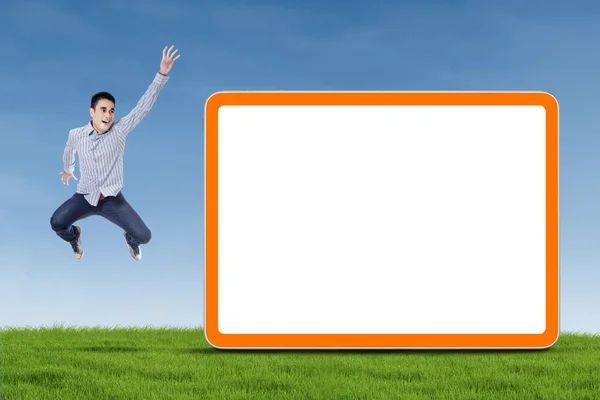 Homem pulando com placa em branco — Fotografia de Stock