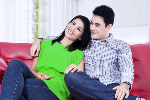 Couple asiatique relaxant sur un canapé rouge à la maison — Photo