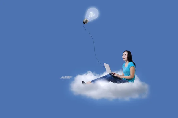 Asian student using laptop over cloud — Stock Photo, Image