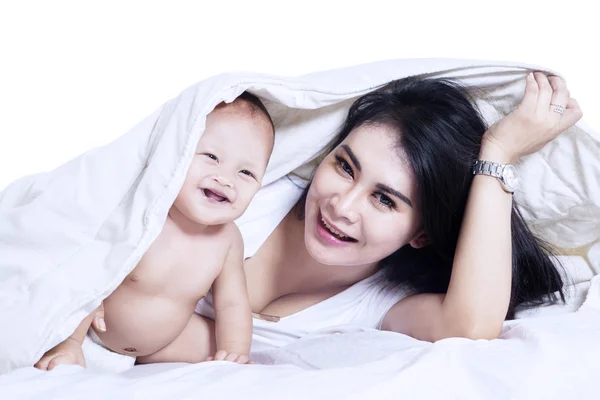 Jovem mãe e bebê brincando sob cobertor — Fotografia de Stock