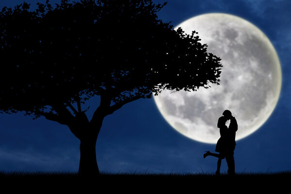 Couple kissing by a tree on blue full moon silhouette background