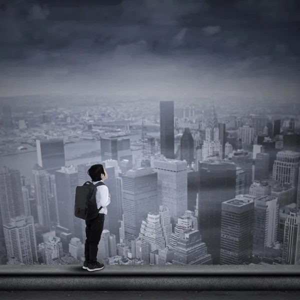 Young businessman standing on the top of skyscraper — Stock Photo, Image