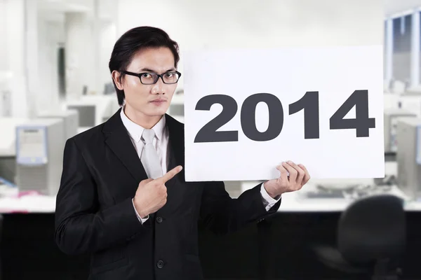 Uomo d'affari asiatico che punta un cartellone del 2014 — Foto Stock