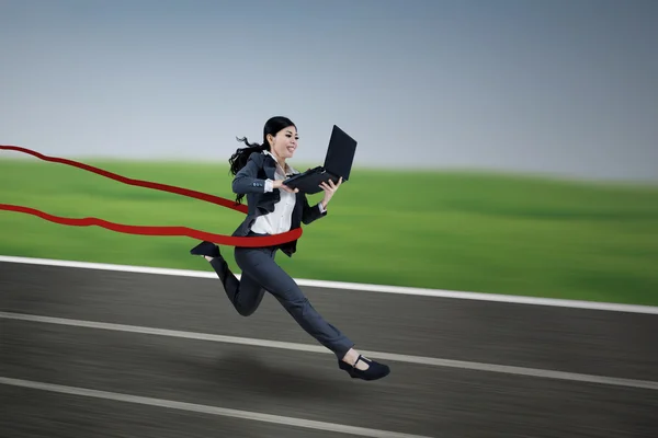 Ejecutiva mujer de negocios corriendo y sosteniendo portátil —  Fotos de Stock