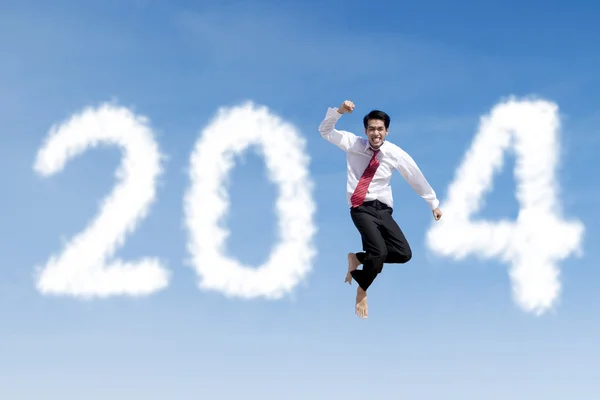 Homem de negócios feliz salta com nuvens de 2014 — Fotografia de Stock