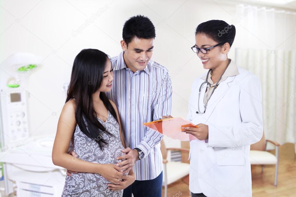 Pregnant couple visiting a female doctor