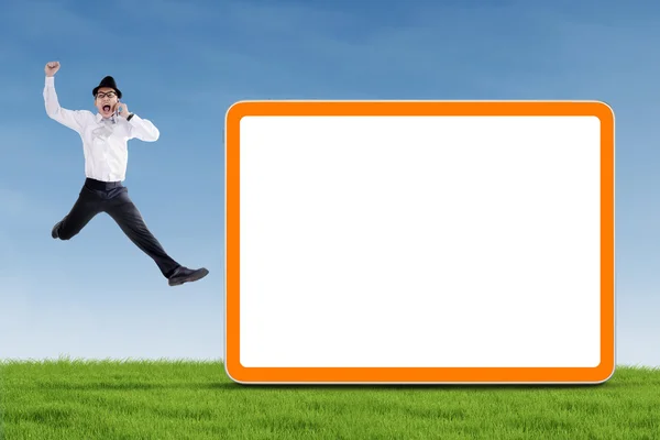 Happy businessman jumping with blank board — Stock Photo, Image