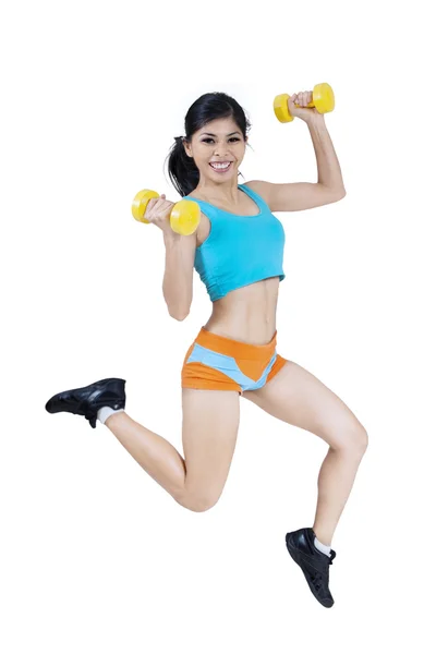 Sporty woman jumping with dumbbells — Stock Photo, Image