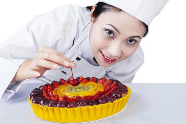 Kvinna kock dekorerar en tårta Stockbild