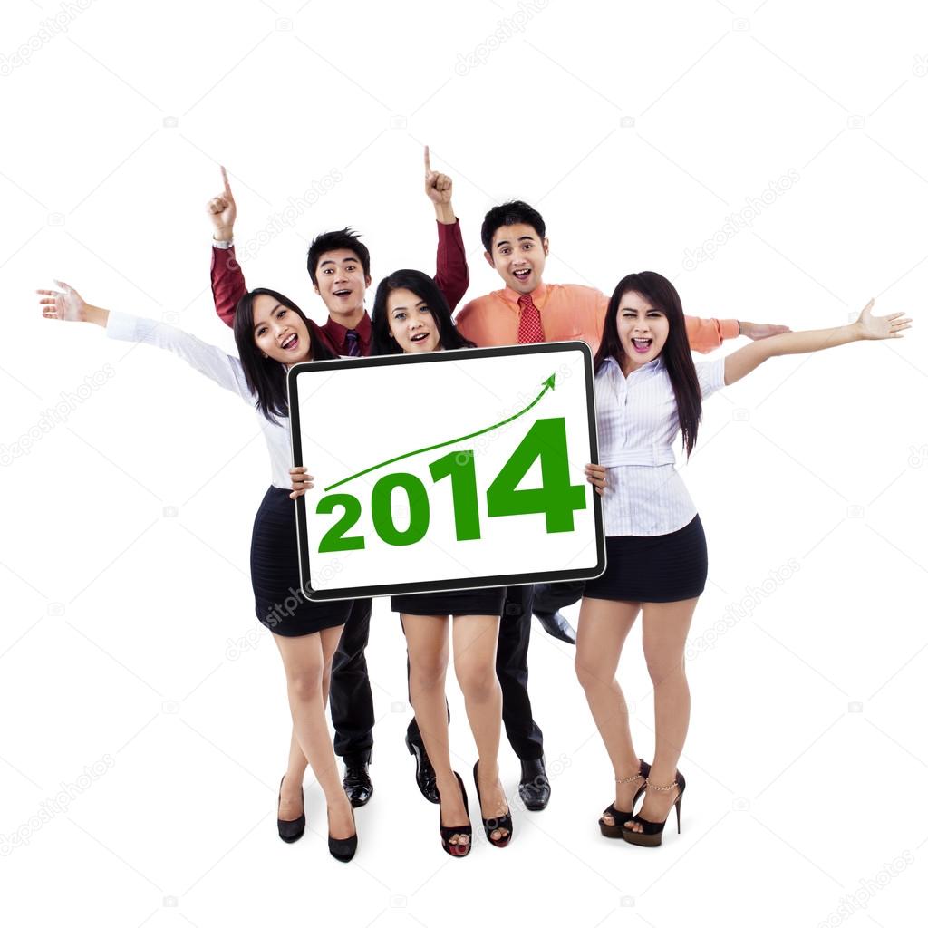 Happy business team showing the new year 2014