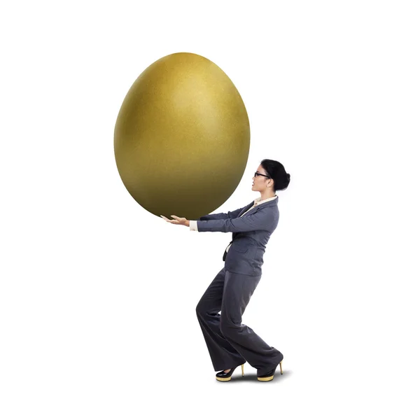 Junge Geschäftsfrau trägt goldenes Ei — Stockfoto