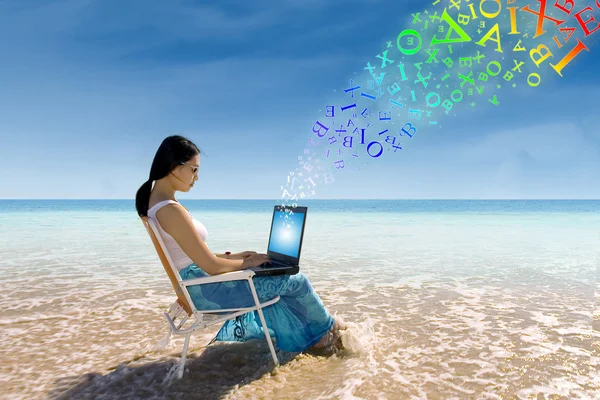 Mujer joven trabajando en la playa — Foto de Stock