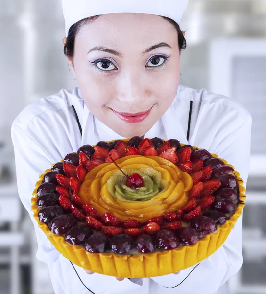 Chef feminino segurando um bolo de frutas — Fotografia de Stock