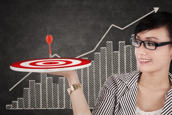Businesswoman holding up a target — Stock Photo, Image