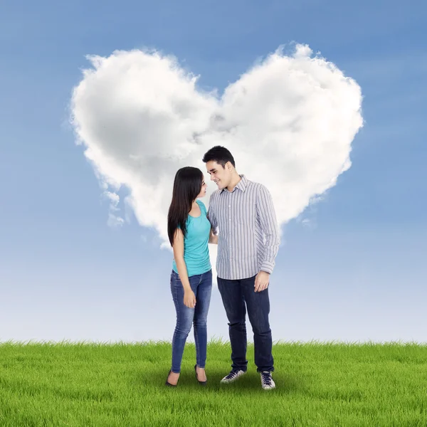 Pareja feliz con corazón en el prado — Foto de Stock