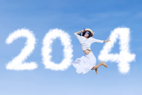 Woman jumping with new year 2014 on the sky — Stock Photo, Image