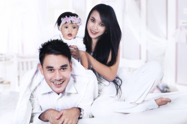 Mutlu aile yatakta oynuyor.