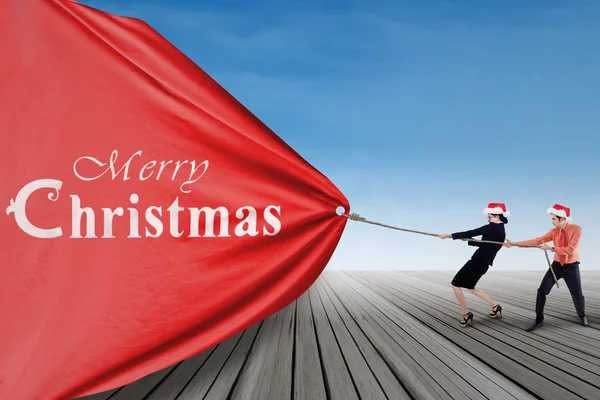 Asian businessteam pull christmas banner — Stock Photo, Image