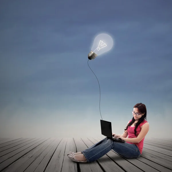 Mooie vrouw die op laptop onder verlichte gloeilamp buiten werkt — Stockfoto