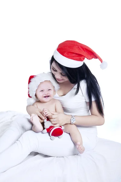 Mãe feliz com seu bebê em santa chapéu — Fotografia de Stock