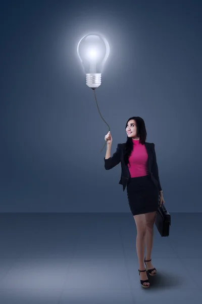 Businesswoman holding light bulb — Stock Photo, Image