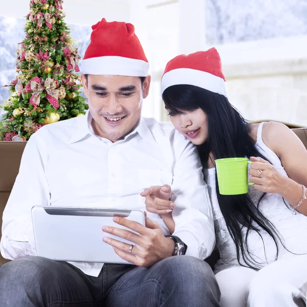 Рождественская пара с помощью цифрового планшета для покупок в Интернете — стоковое фото