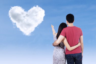 genç bir çift kalp bulutlara işaret