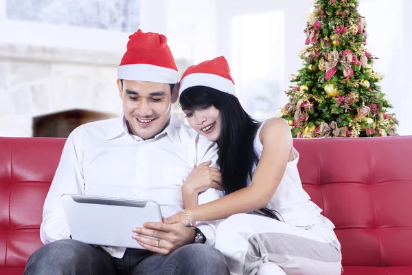 Christmas couple with a tablet — Stock Photo, Image