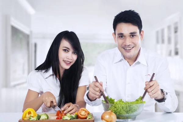 Pareja feliz preparando ensalada — Foto de Stock