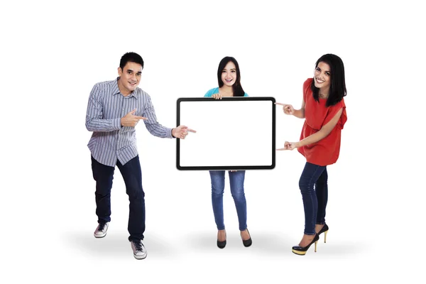 Jovens felizes segurando cartaz em branco — Fotografia de Stock