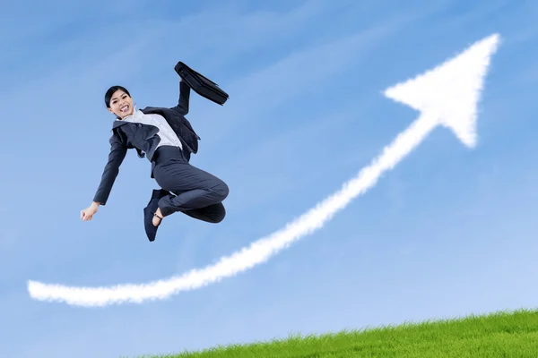 Empresária bem sucedida pulando com sinal de seta — Fotografia de Stock