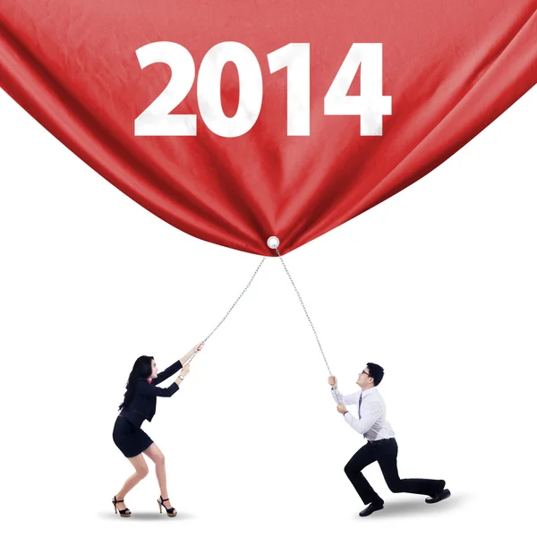 Trabalho em equipe puxando a bandeira do ano novo de 2014 — Fotografia de Stock
