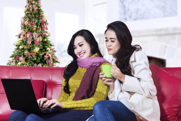 Twee gelukkige vrouwen met behulp van een laptop — Stockfoto