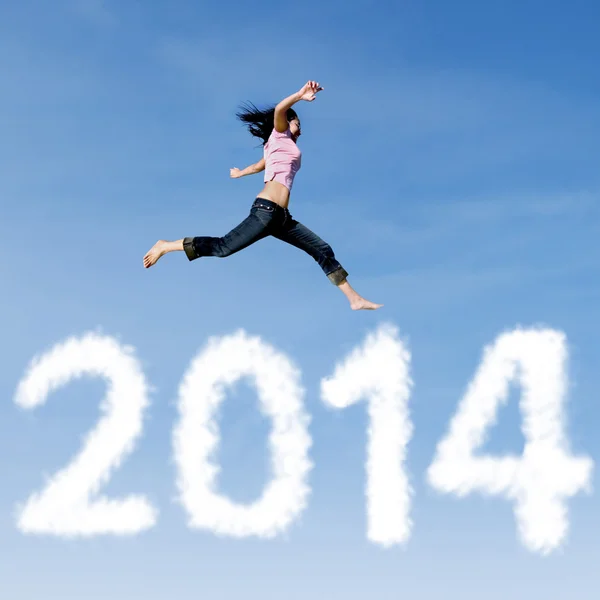 Woman jumping with new year 2014 of clouds — Stock Photo, Image