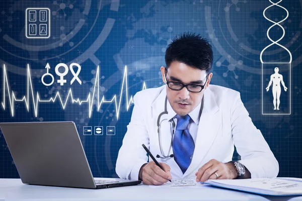 Joven médico trabajando delante de la computadora portátil — Foto de Stock