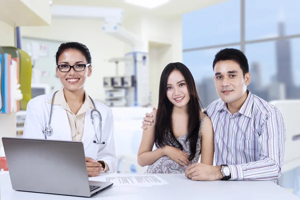 Een vrouwelijke arts met Aziatische paar in het kantoor van arts — Stockfoto