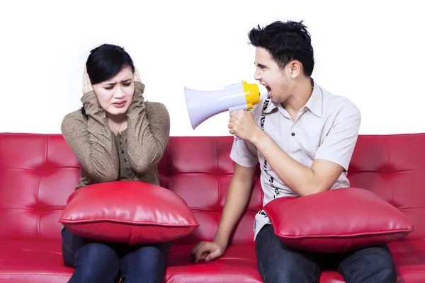 Boos vriendje met behulp van spreker op vriendin — Stockfoto