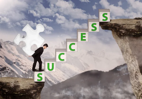 Businessman bring puzzle symbol of success at mountain — Stock Photo, Image