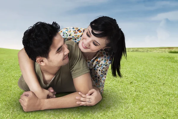 Paar liggend op gras — Stockfoto