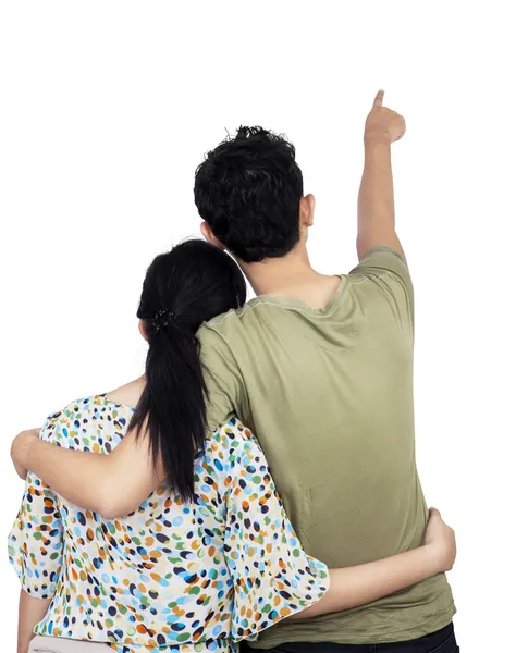 Pareja joven apuntando a la pared — Foto de Stock