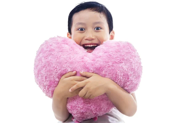 Criança abraçando um travesseiro de coração — Fotografia de Stock