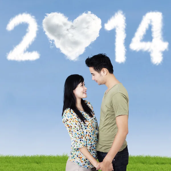 Pareja romántica con nubes en forma de 2014 — Foto de Stock