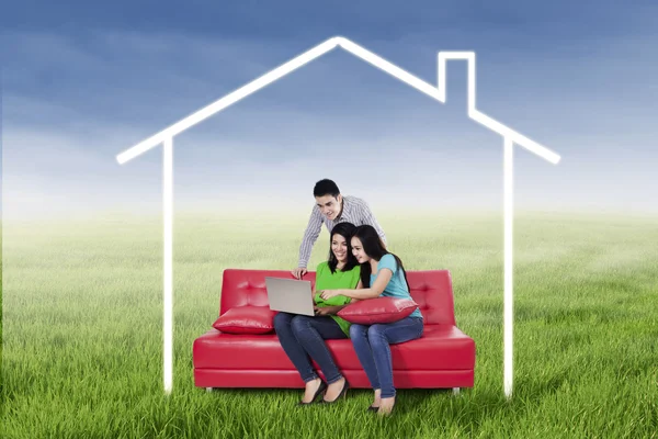 Three young friends using a laptop — Stock Photo, Image