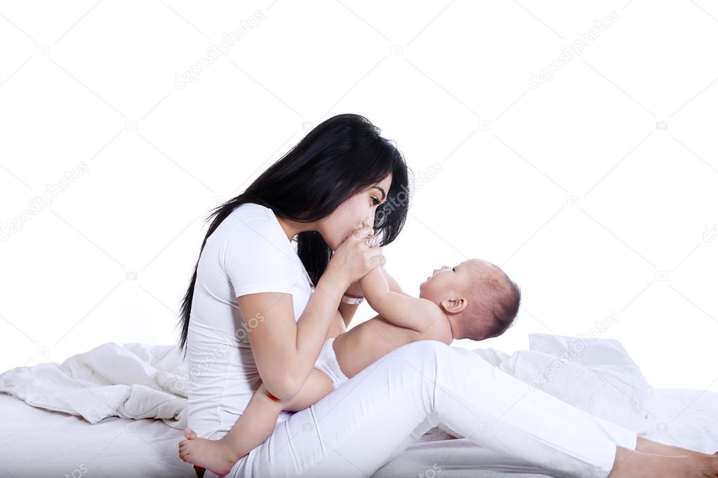 Young mother kissed her baby isolated