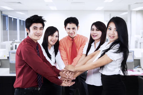 Business team joining their hands in the office — Stock Photo, Image