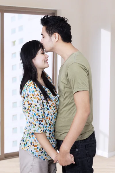 Муж целует жену в новом доме — стоковое фото