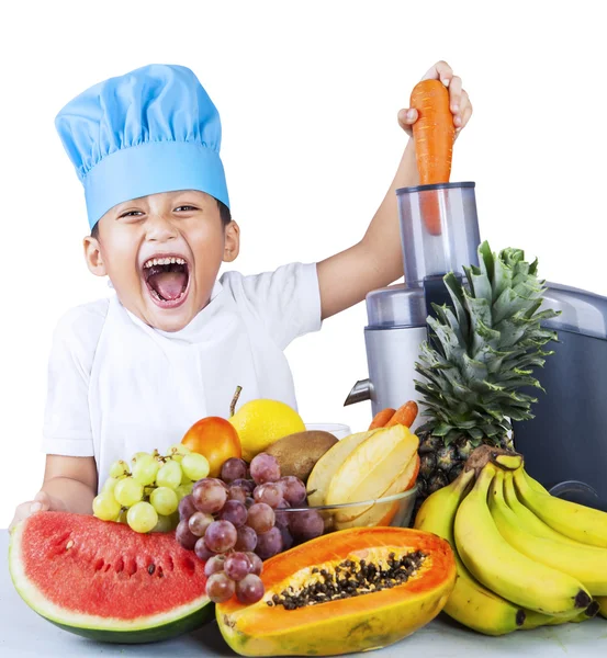 Malý chlapec dělat ovocné šťávy — Stock fotografie